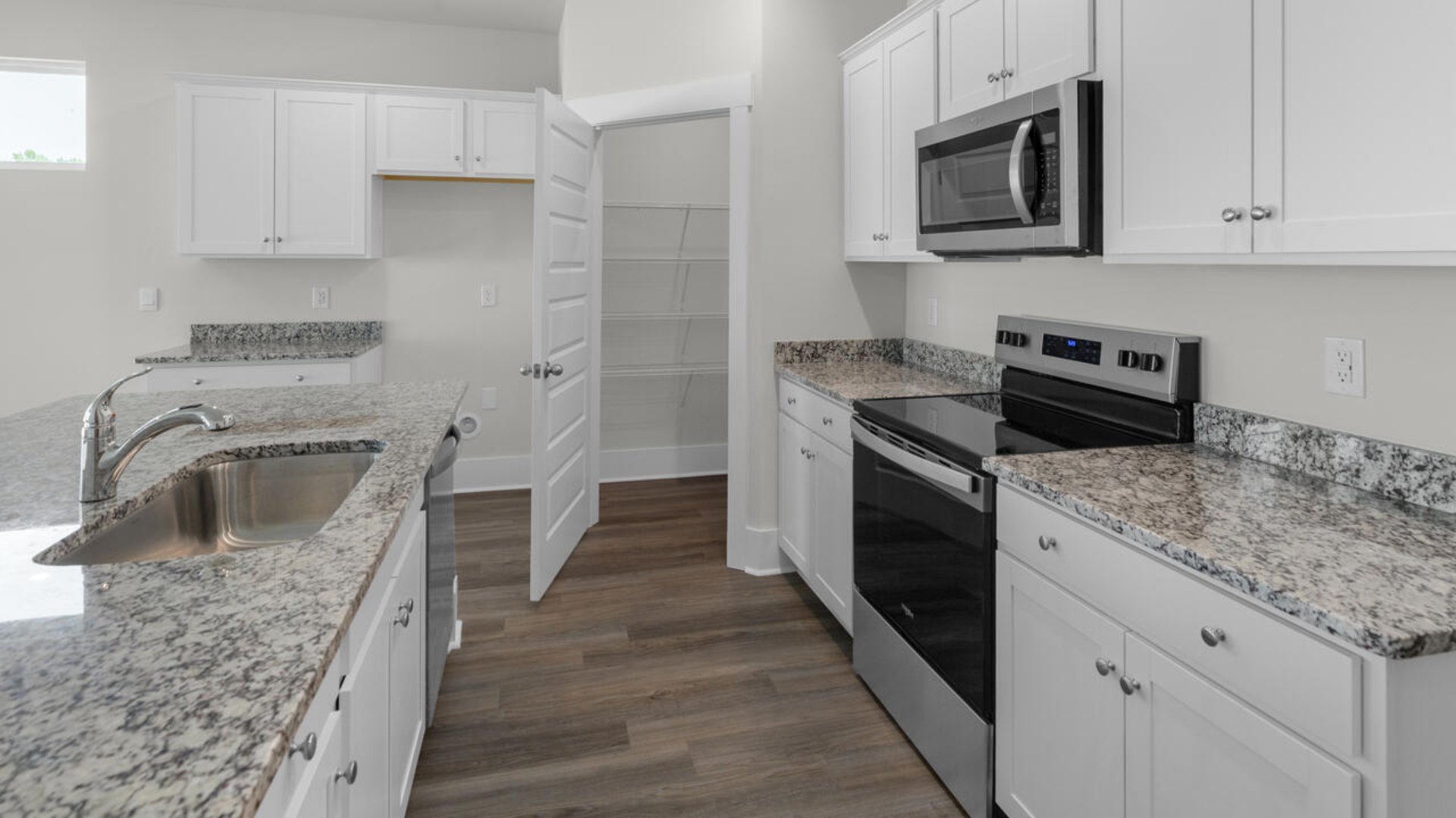 This home boasts stainless steel appliances, a large granite kitchen island that overlooks the dining area and patio, as well as a 45-degree angle pantry for ample food storage