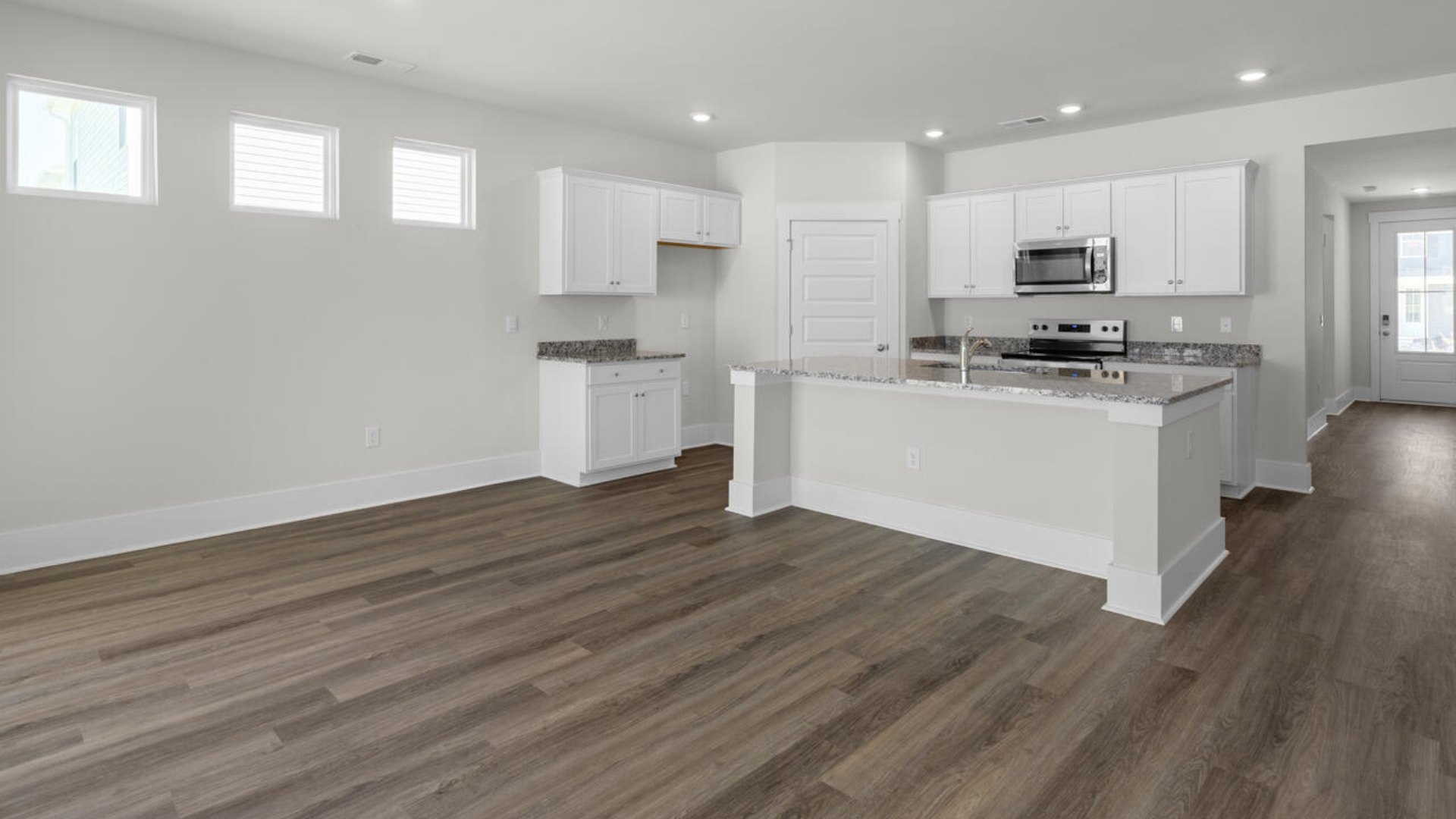 This home boasts stainless steel appliances, a large granite kitchen island that overlooks the dining area and patio, as well as a 45-degree angle pantry for ample food storage