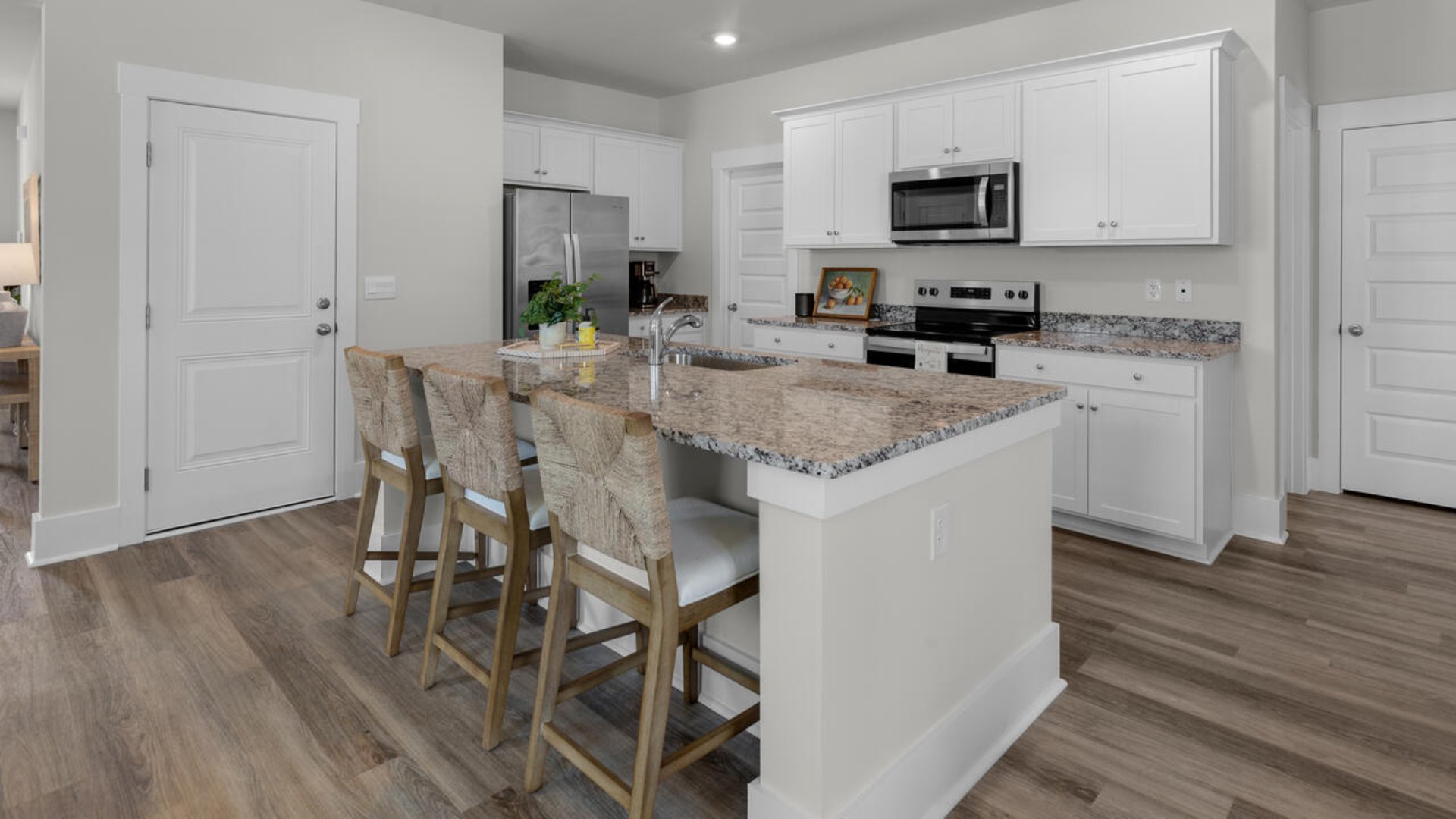 The gourmet kitchen stands out with its elegant granite countertops and Whirlpool stainless steel appliance package. Throughout the home, Luxury Vinyl Plank (LVP) flooring and stain-resistant carpets offer durability and comfort.