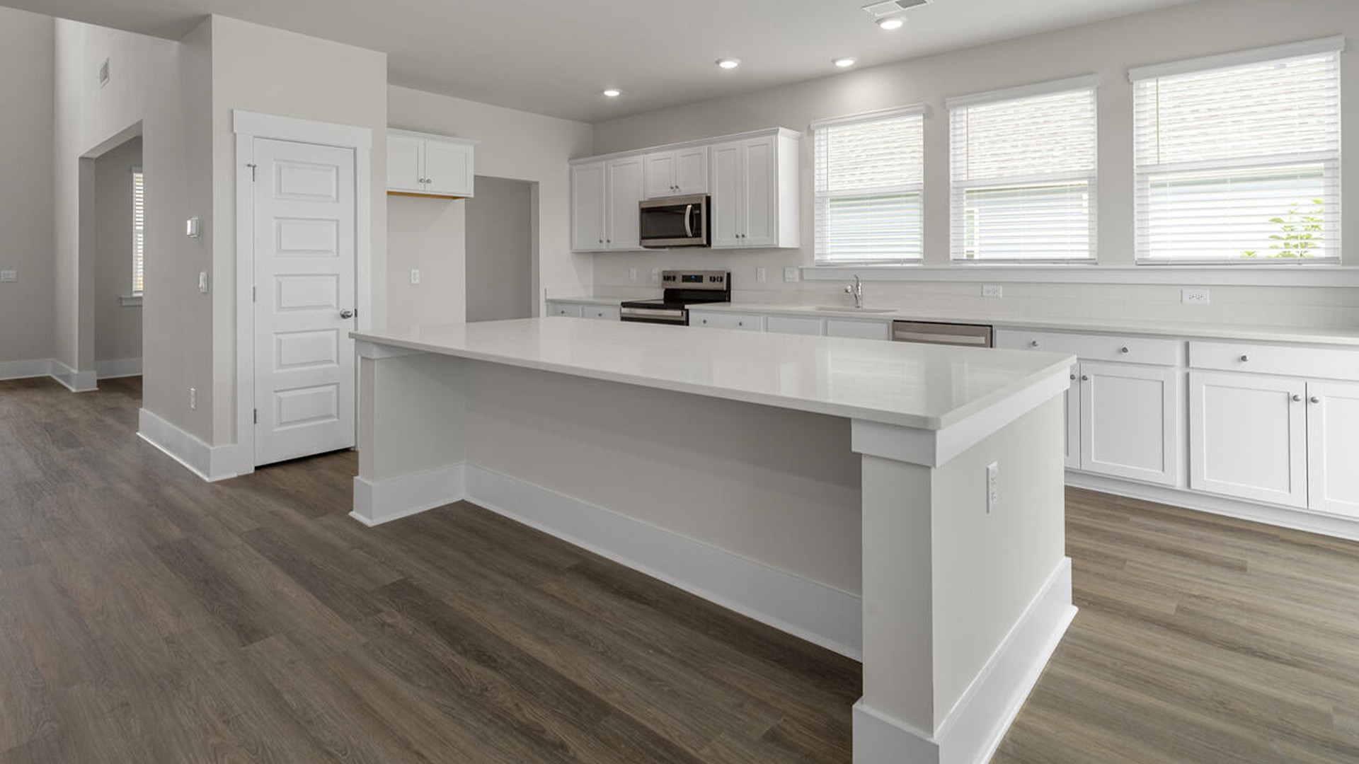 A large kitchen featuring granite countertops, stainless steel appliances and an island that offers ample room for food preparation and casual dinin