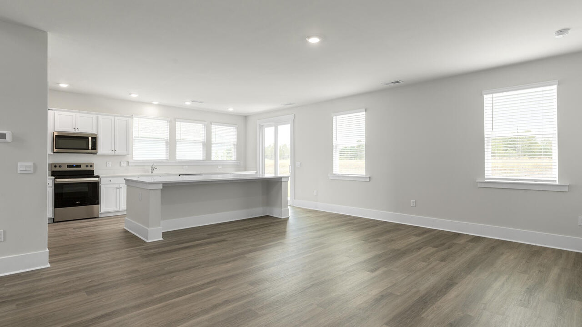 A large kitchen featuring granite countertops, stainless steel appliances and an island that offers ample room for food preparation and casual dinin