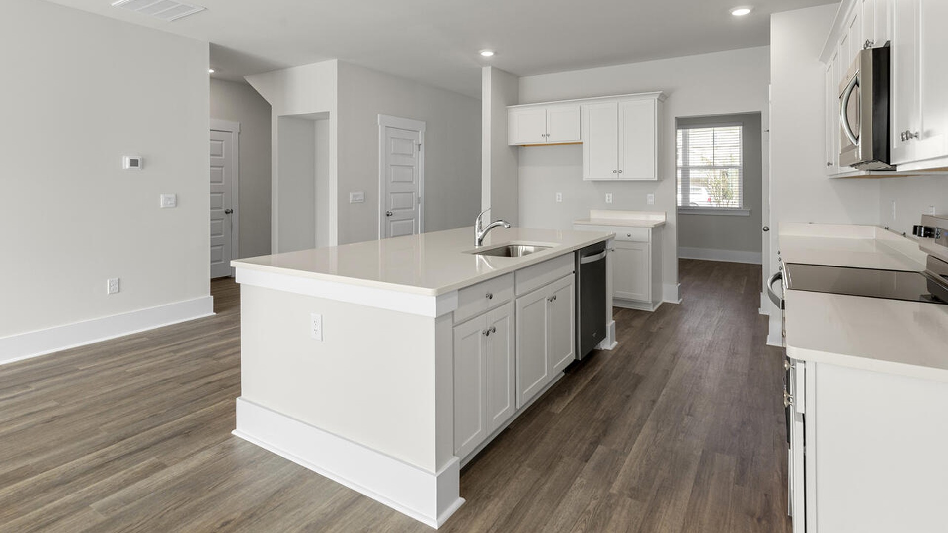 an open concept kitchen and family room that serves as the heart of the home, complete with a generous kitchen island for meal prep and additional seating.