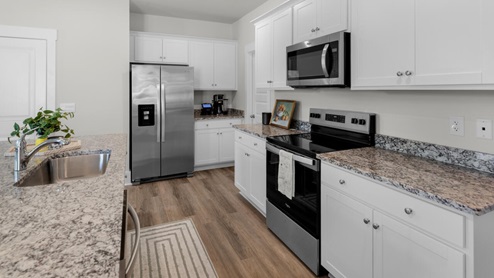 The kitchen features shaker-style cabinets, granite countertops, and stainless steel appliances, which are sure to both turn heads and make meal prep easy. You’ll never be too far from the action with the living and dining area right there.