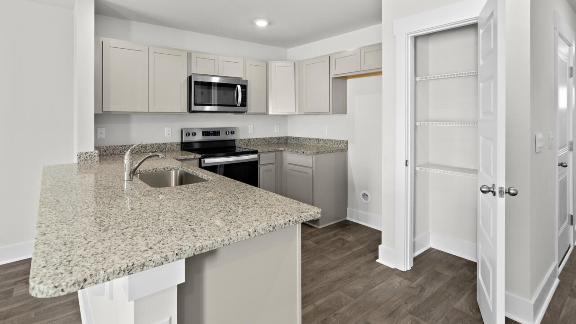 The kitchen overlooks the dining and living spaces, ideal for entertaining guests or enjoying family time while preparing meals with new stainless-steel appliances and granite countertops.