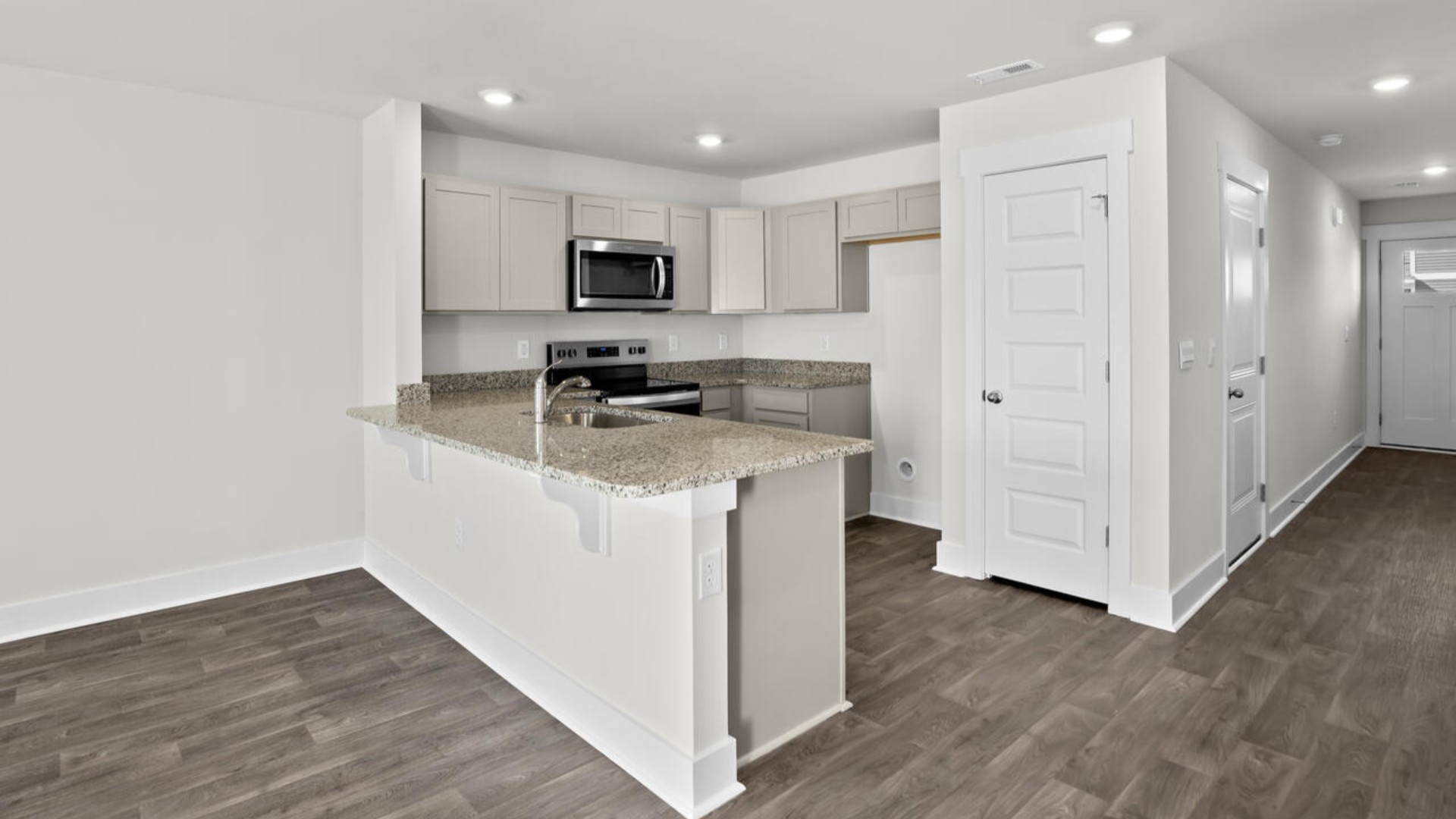 The kitchen overlooks the dining and living spaces, ideal for entertaining guests or enjoying family time while preparing meals with new stainless-steel appliances and granite countertops.