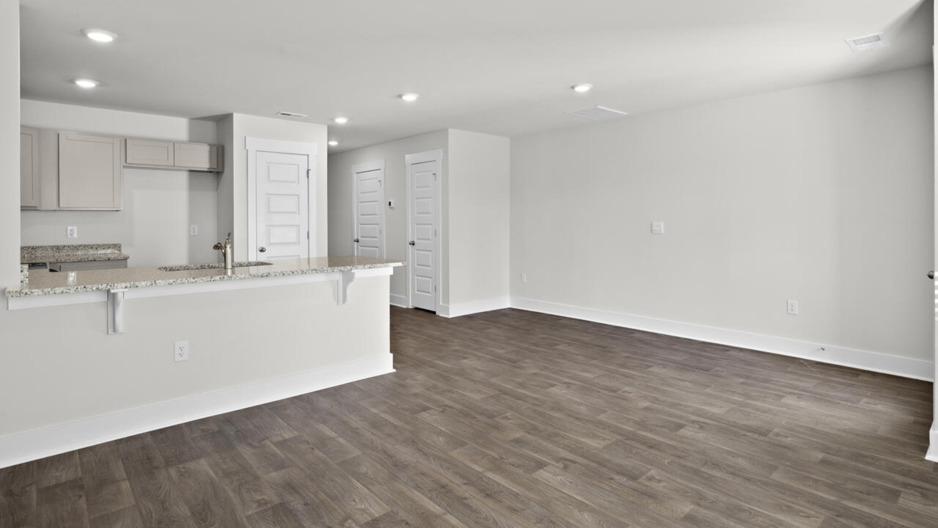 The kitchen overlooks the dining and living spaces, ideal for entertaining guests or enjoying family time while preparing meals with new stainless-steel appliances and granite countertops.