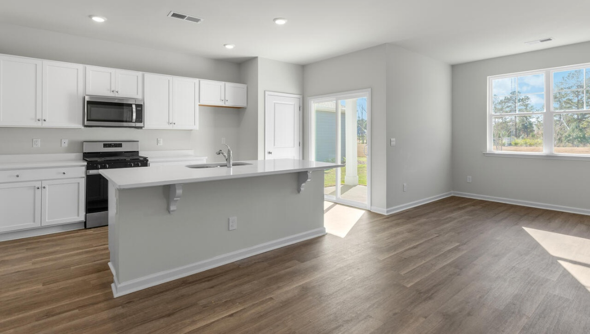 New Homes in Leland NC. The Kerry floor plan offers open living space and a 2-car garage. At the front are two guest bedrooms and a full bathroom, perfect for visitors or a home office. The open-concept family room, kitchen, and dining area feature Granite countertops, stainless steel appliances, including a smooth-top range, dishwasher and overhead microwave