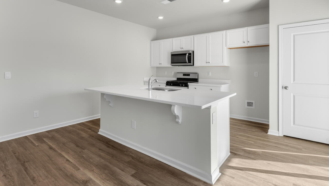 New Homes in Leland NC. The Kerry floor plan offers open living space and a 2-car garage. At the front are two guest bedrooms and a full bathroom, perfect for visitors or a home office. The open-concept family room, kitchen, and dining area feature Granite countertops, stainless steel appliances, including a smooth-top range, dishwasher and overhead microwave