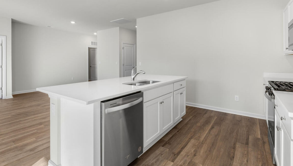 New Homes in Leland NC. The Kerry floor plan offers open living space and a 2-car garage. At the front are two guest bedrooms and a full bathroom, perfect for visitors or a home office. The open-concept family room, kitchen, and dining area feature Granite countertops, stainless steel appliances, including a smooth-top range, dishwasher and overhead microwave