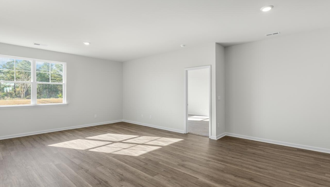 New Homes in Leland NC. The Kerry floor plan offers open living space and a 2-car garage. At the front are two guest bedrooms and a full bathroom, perfect for visitors or a home office. The open-concept family room, kitchen, and dining area feature Granite countertops, stainless steel appliances, including a smooth-top range, dishwasher and overhead microwave