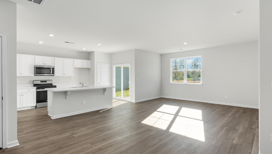 New Homes in Leland NC. The Kerry floor plan offers open living space and a 2-car garage. At the front are two guest bedrooms and a full bathroom, perfect for visitors or a home office. The open-concept family room, kitchen, and dining area feature Granite countertops, stainless steel appliances, including a smooth-top range, dishwasher and overhead microwave