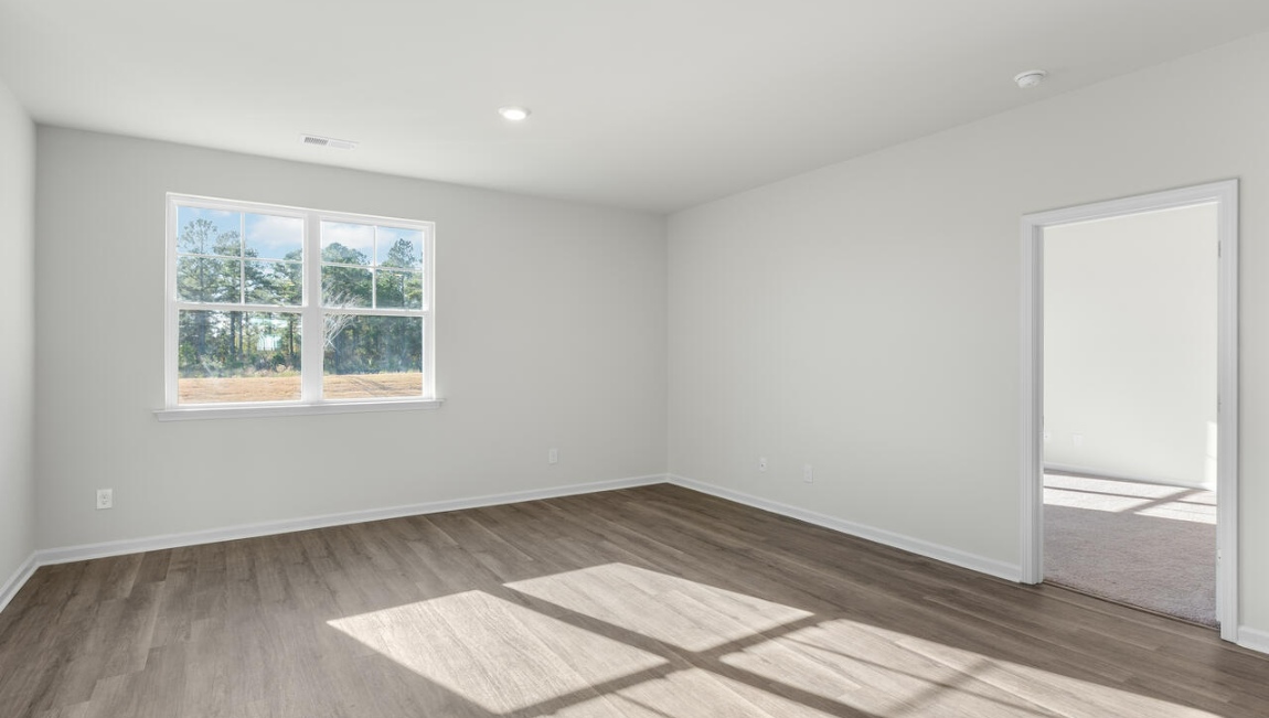 New Homes in Leland NC. The Kerry floor plan offers open living space and a 2-car garage. At the front are two guest bedrooms and a full bathroom, perfect for visitors or a home office. The open-concept family room, kitchen, and dining area feature Granite countertops, stainless steel appliances, including a smooth-top range, dishwasher and overhead microwave