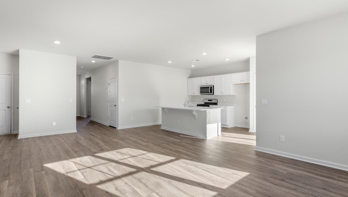 New Homes in Leland NC. The Kerry floor plan offers open living space and a 2-car garage. At the front are two guest bedrooms and a full bathroom, perfect for visitors or a home office. The open-concept family room, kitchen, and dining area feature Granite countertops, stainless steel appliances, including a smooth-top range, dishwasher and overhead microwave