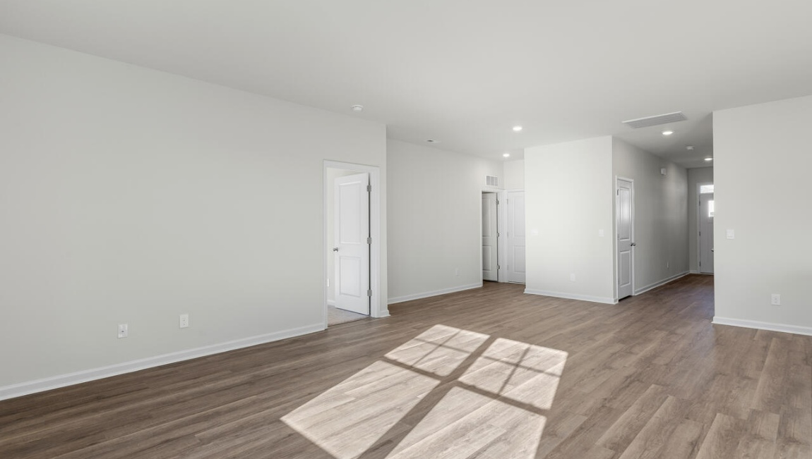 New Homes in Leland NC. The Kerry floor plan offers open living space and a 2-car garage. At the front are two guest bedrooms and a full bathroom, perfect for visitors or a home office. The open-concept family room, kitchen, and dining area feature Granite countertops, stainless steel appliances, including a smooth-top range, dishwasher and overhead microwave