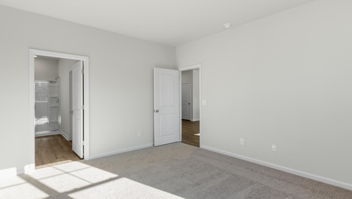 New Homes in Leland NC. The Kerry floor plan offers open living space and a 2-car garage. At the front are two guest bedrooms and a full bathroom, perfect for visitors or a home office. The open-concept family room, kitchen, and dining area feature Granite countertops, stainless steel appliances, including a smooth-top range, dishwasher and overhead microwave