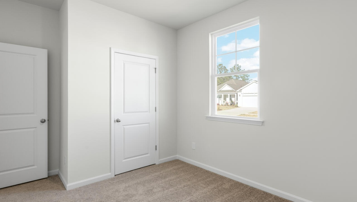 New Homes in Leland NC. The Kerry floor plan offers open living space and a 2-car garage. At the front are two guest bedrooms and a full bathroom, perfect for visitors or a home office. The open-concept family room, kitchen, and dining area feature Granite countertops, stainless steel appliances, including a smooth-top range, dishwasher and overhead microwave