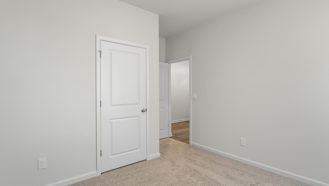 New Homes in Leland NC. The Kerry floor plan offers open living space and a 2-car garage. At the front are two guest bedrooms and a full bathroom, perfect for visitors or a home office. The open-concept family room, kitchen, and dining area feature Granite countertops, stainless steel appliances, including a smooth-top range, dishwasher and overhead microwave