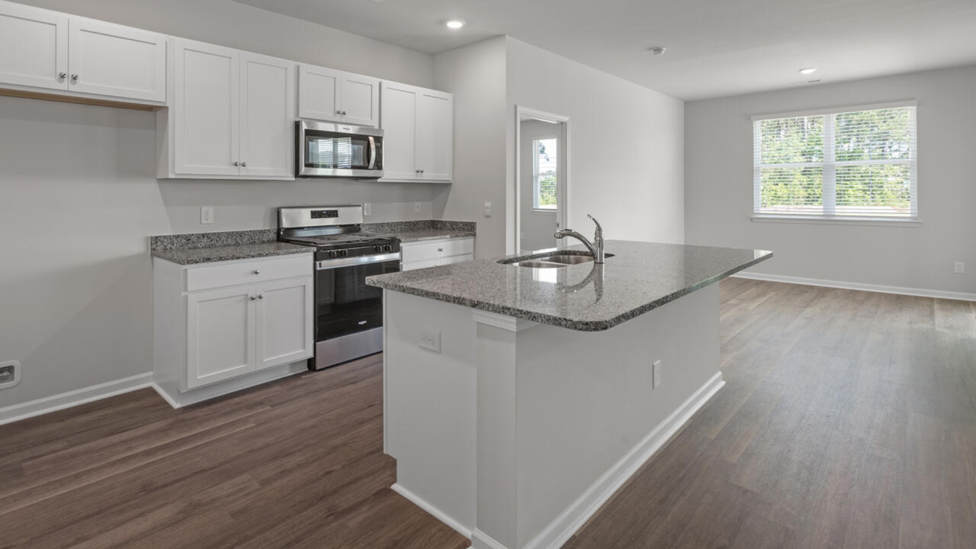The kitchen features a large island, granite countertops, and stainless steel appliances, which are sure to both turn heads and make meal prep easy.