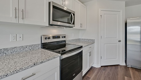open-concept kitchen features granite countertops and stainless steel appliances. The kitchen seamlessly connects to the dining and living areas, creating a great space for entertainment. I