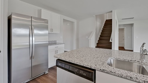 open-concept kitchen features granite countertops and stainless steel appliances. The kitchen seamlessly connects to the dining and living areas, creating a great space for entertainment. I