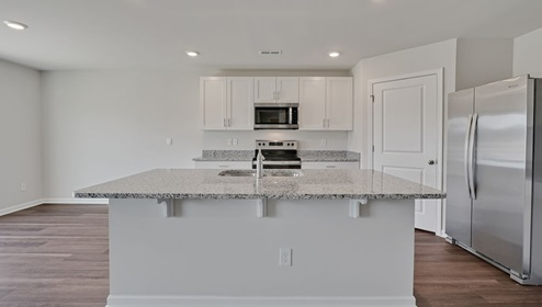 open-concept kitchen features granite countertops and stainless steel appliances. The kitchen seamlessly connects to the dining and living areas, creating a great space for entertainment. I