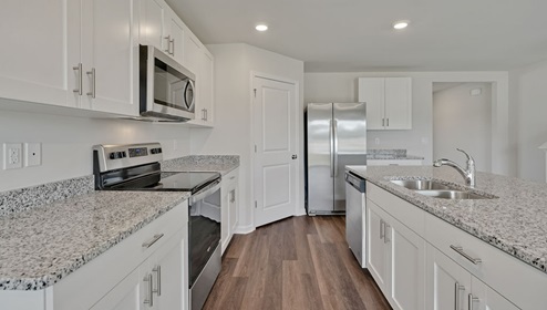 open-concept kitchen features granite countertops and stainless steel appliances. The kitchen seamlessly connects to the dining and living areas, creating a great space for entertainment. I