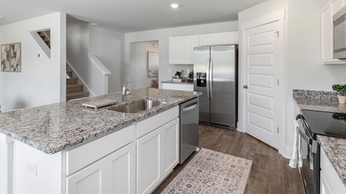 The kitchen features beautiful cabinets, granite countertops, and stainless steel appliances, which are sure to both turn heads and make meal prep easy. You’ll never be too far from the action with the living and dining area right there.