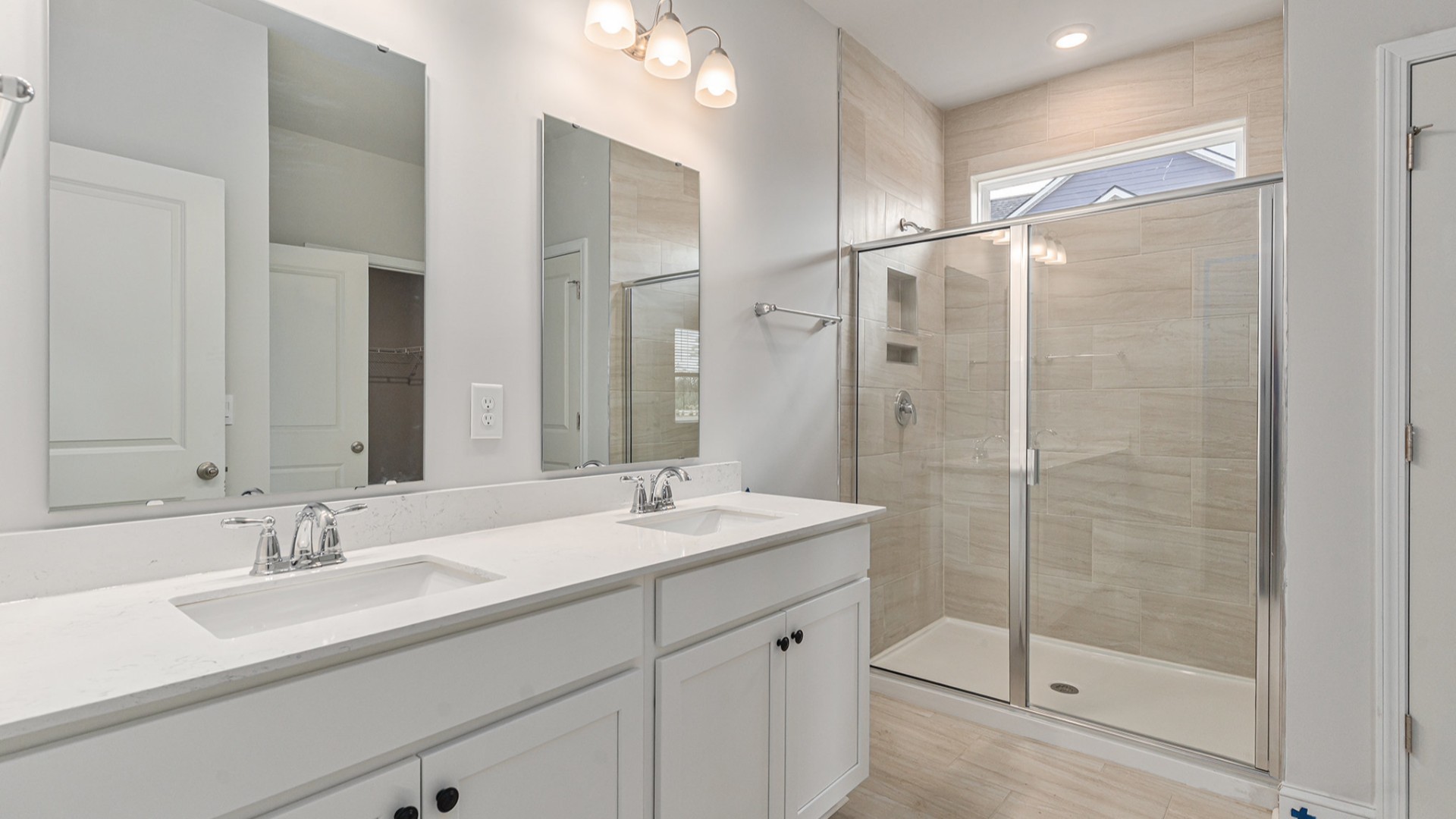 The primary bedroom provides a private retreat with a large walk-in closet and en-suite bathroom featuring dual vanities and a relaxing shower.