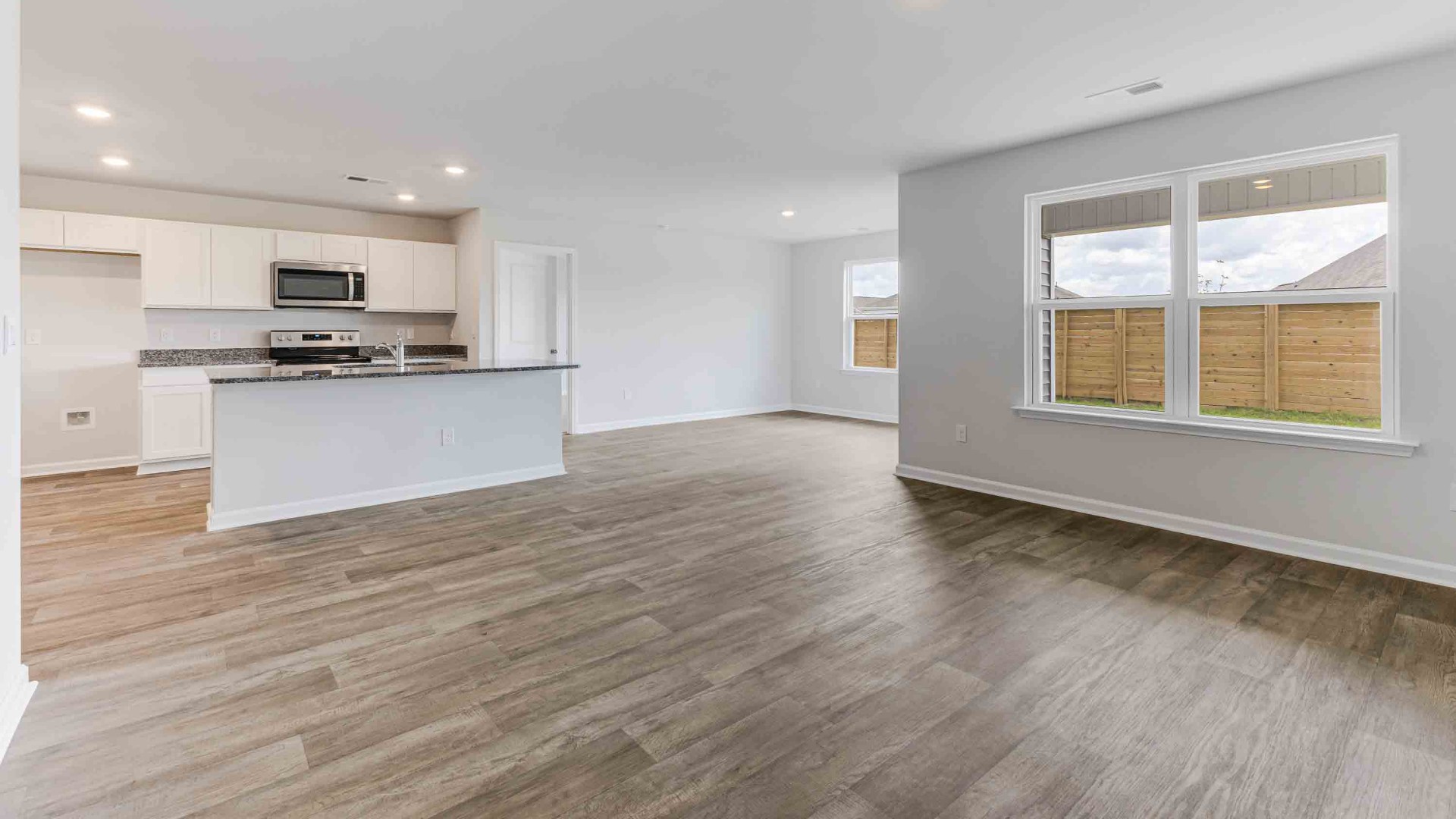 The kitchen features a large island, granite countertops, and stainless steel appliances, which are sure to both turn heads and make meal prep easy.