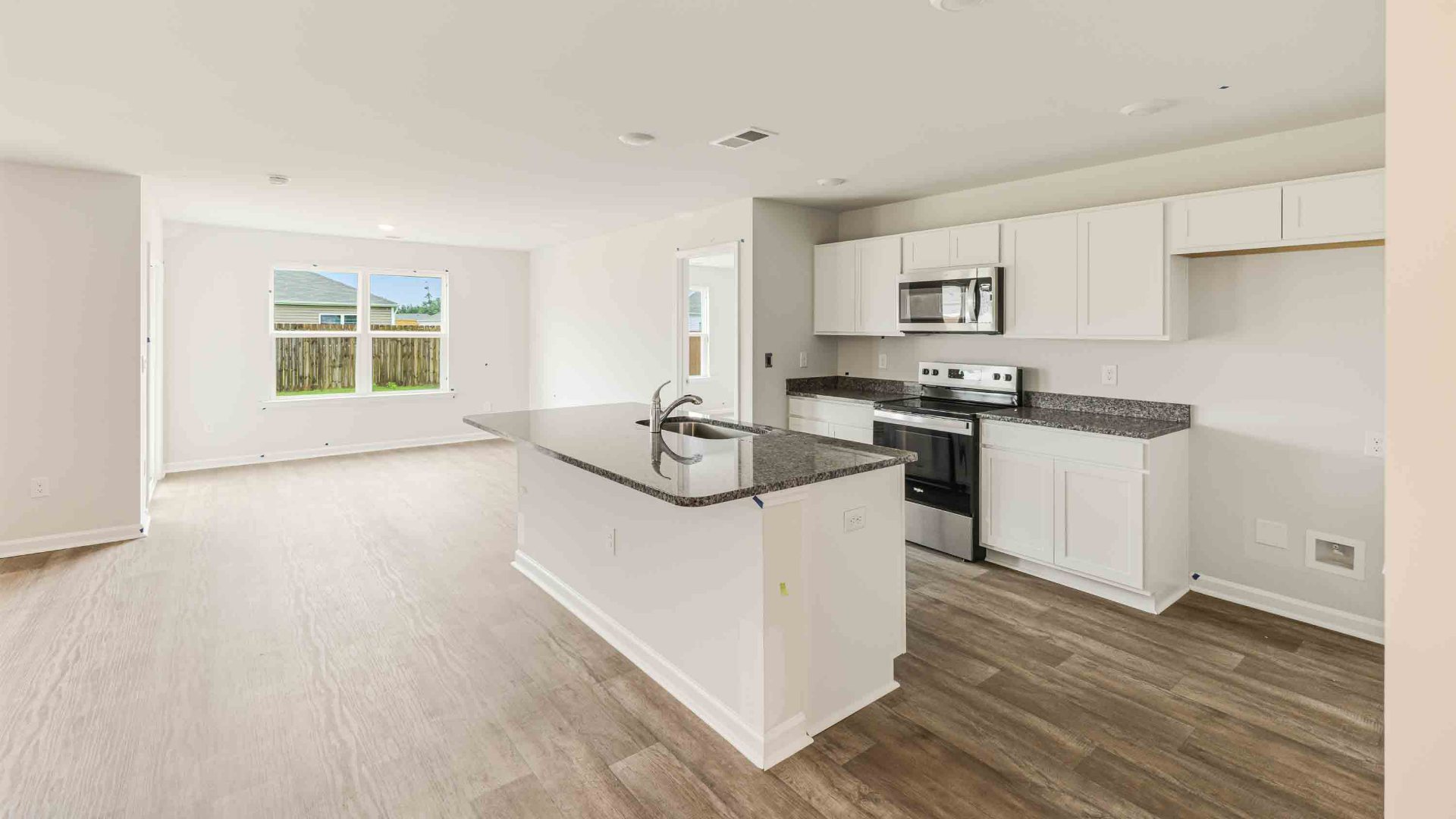 The kitchen features a large island, granite countertops, and stainless steel appliances, which are sure to both turn heads and make meal prep easy.