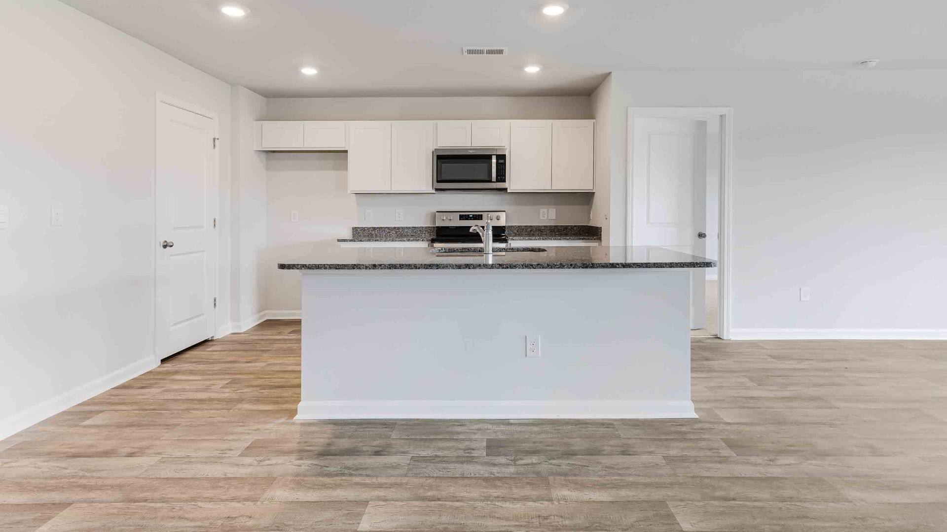 The kitchen features a large island, granite countertops, and stainless steel appliances, which are sure to both turn heads and make meal prep easy.