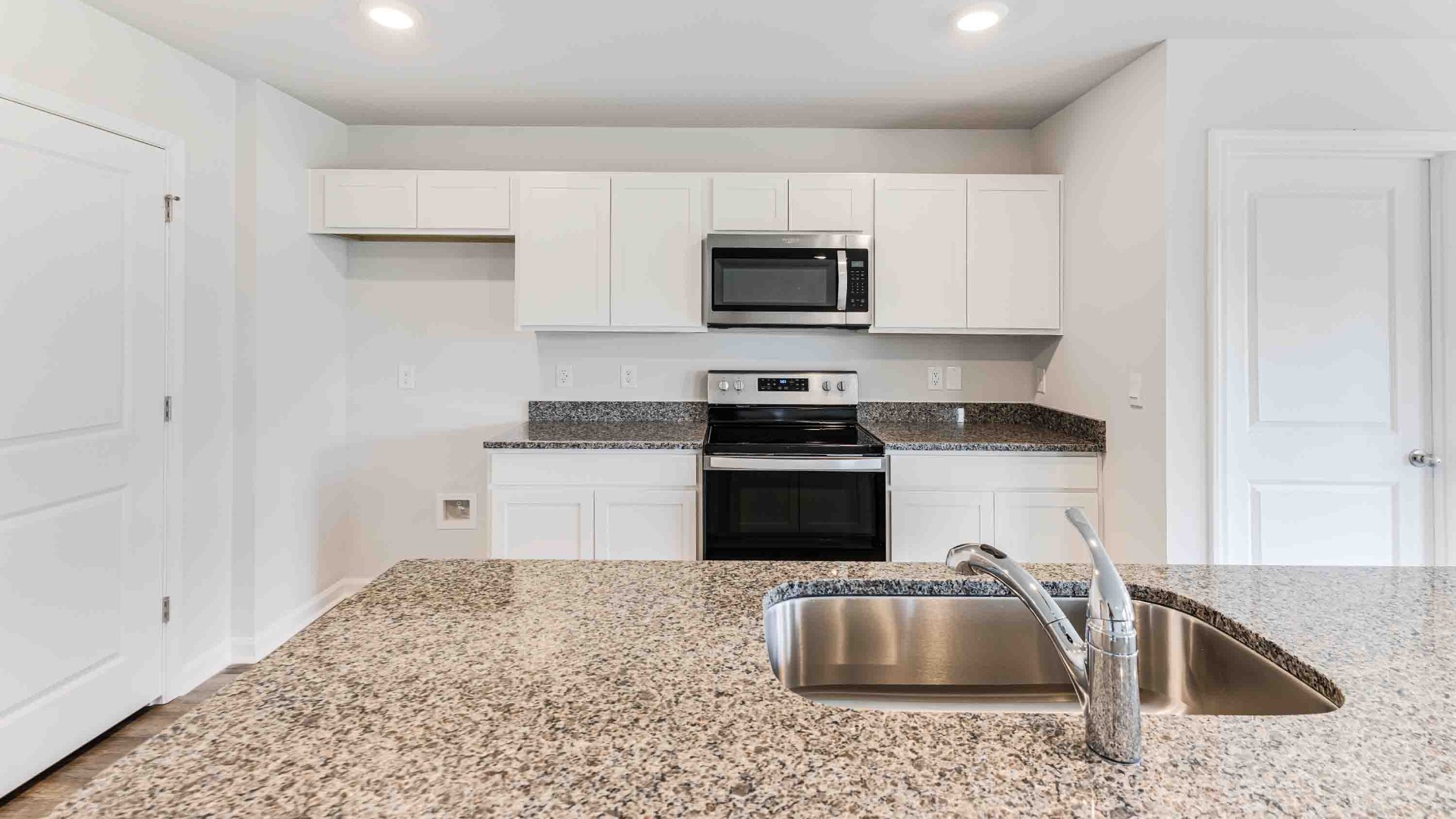 The kitchen features a large island, granite countertops, and stainless steel appliances, which are sure to both turn heads and make meal prep easy.
