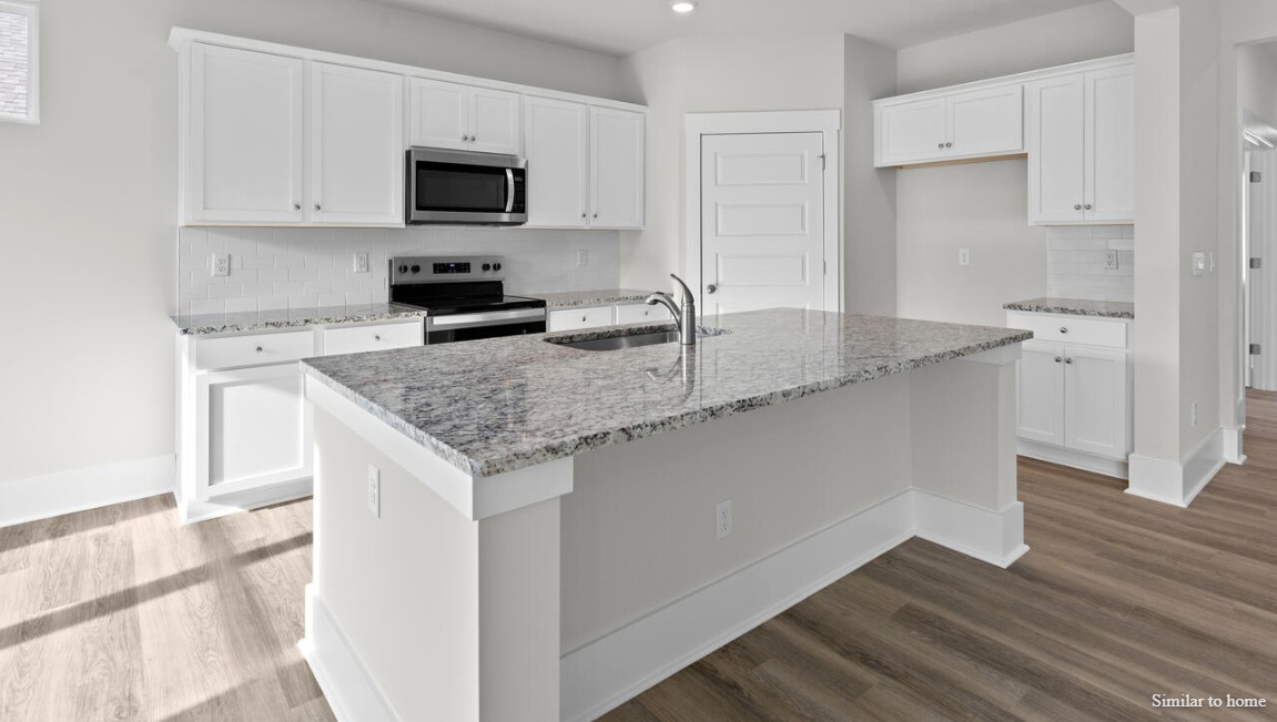 kitchen that features a walk-in pantry, quartz countertops and stainless-steel appliances! Luxury vinyl plank flooring is included throughout the home to handle all your beach days year-round.