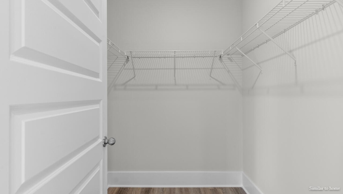 The primary suite, at the rear of the home, includes an en-suite bathroom with a walk-in closet, double vanity, and walk-in shower.