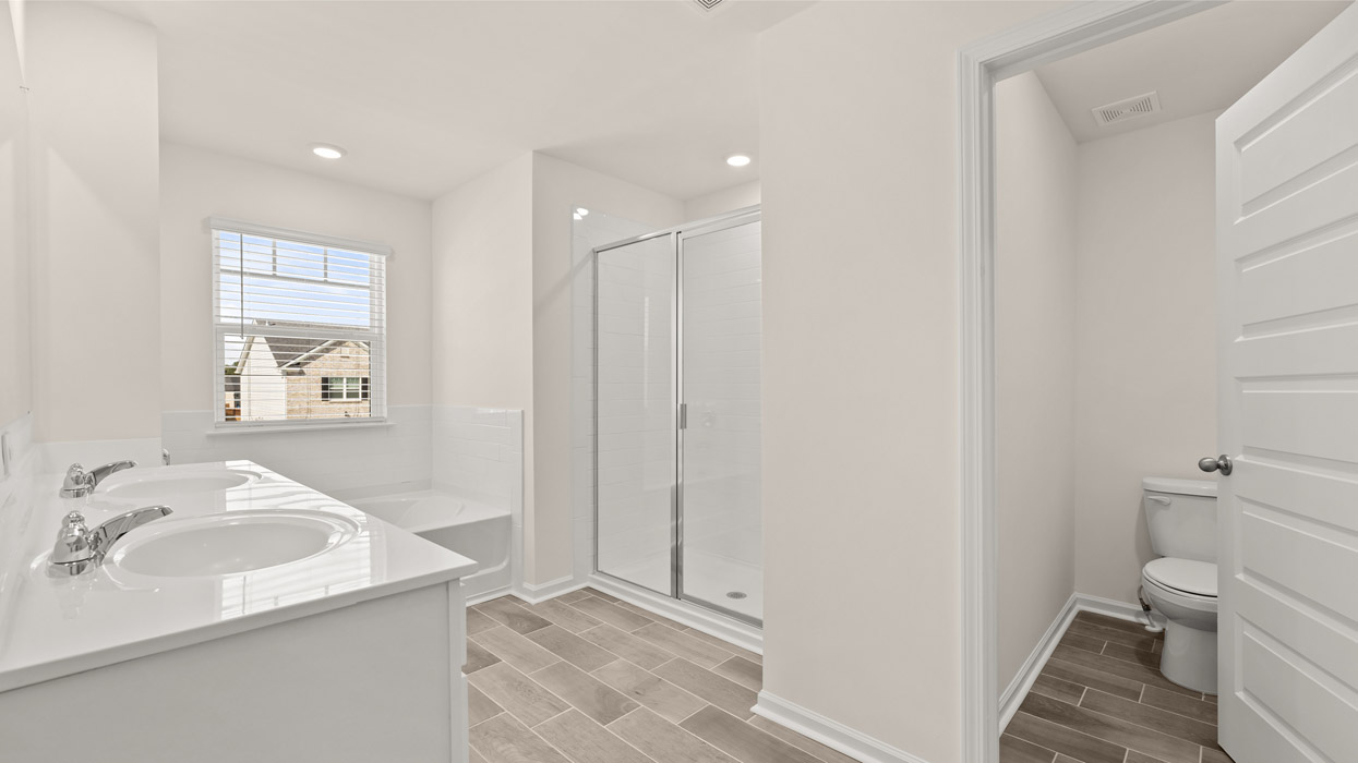 Upstairs there is a generous primary suite with adjoining bath that offers a garden tub, separate shower, dual vanities and plenty of closet space.