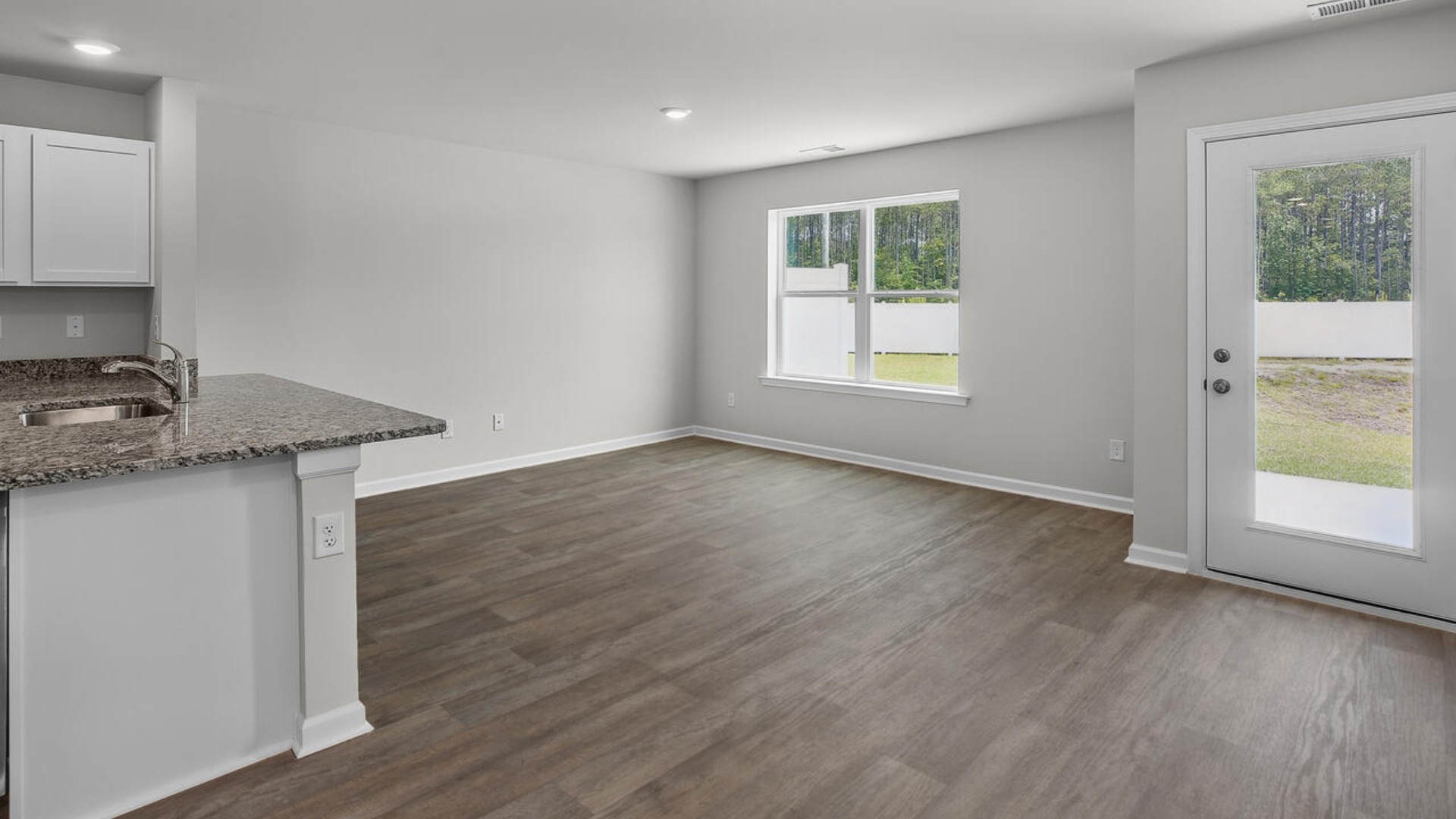 The kitchen overlooks the dining and living spaces, ideal for entertaining guests or enjoying family time while preparing meals with new stainless-steel appliances and granite countertops.