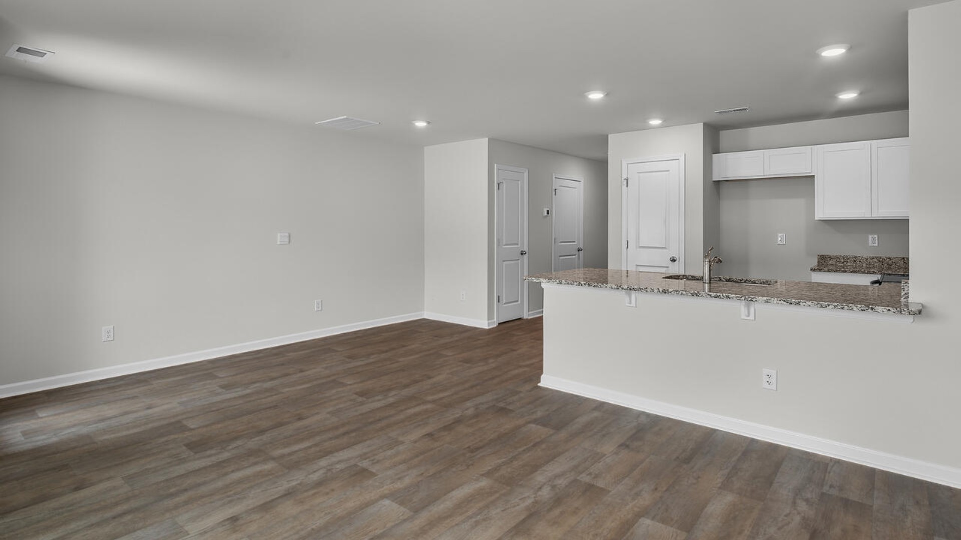 The kitchen overlooks the dining and living spaces, ideal for entertaining guests or enjoying family time while preparing meals with new stainless-steel appliances and granite countertops.