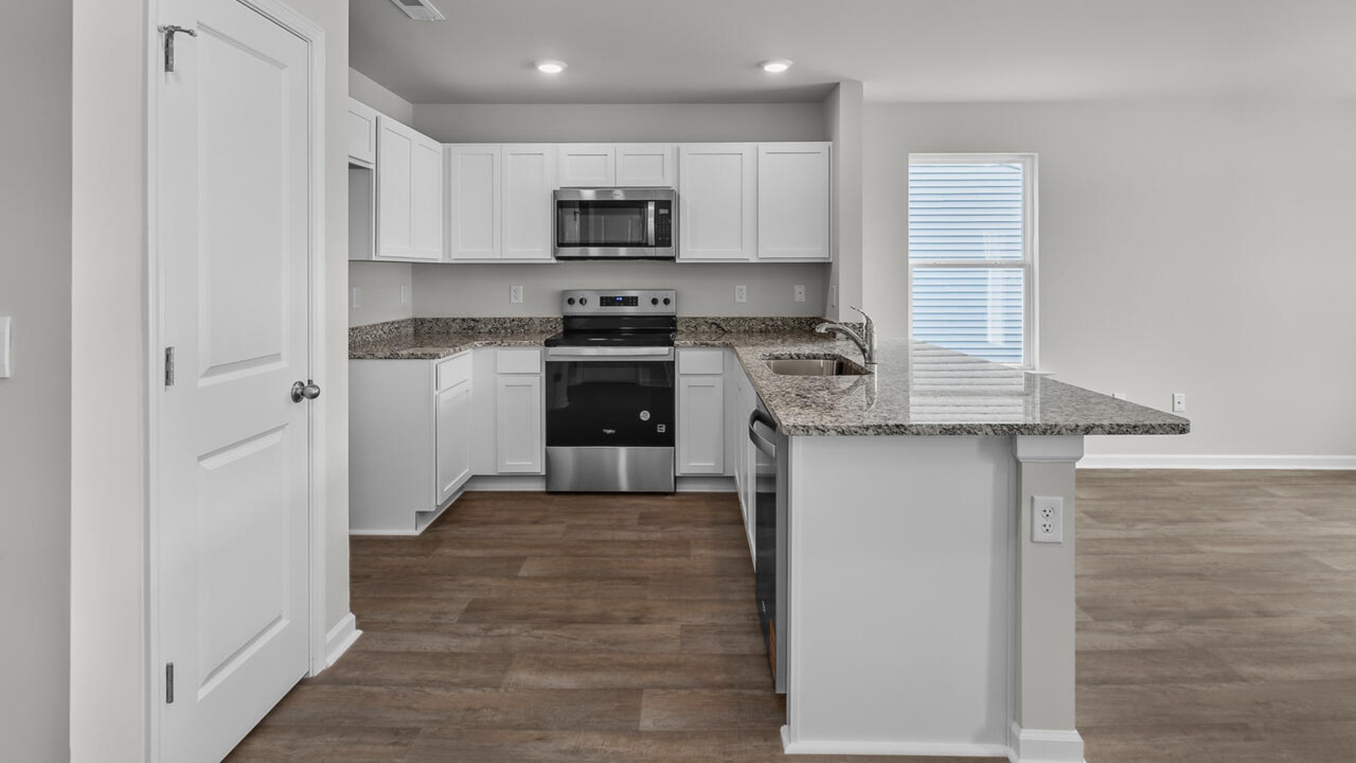 The kitchen overlooks the dining and living spaces, ideal for entertaining guests or enjoying family time while preparing meals with new stainless-steel appliances and Granite countertops.