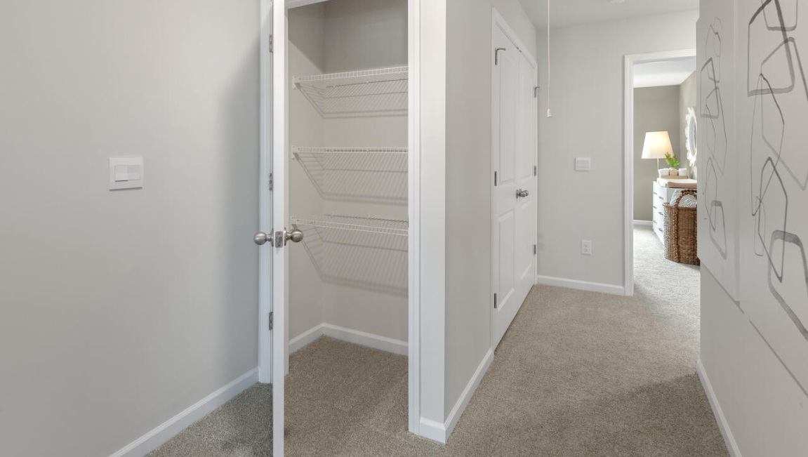 The second floor features the primary bedroom with a walk-in closet and double vanities. It also includes two additional bedrooms, a shared bathroom, and a laundry room for convenience.