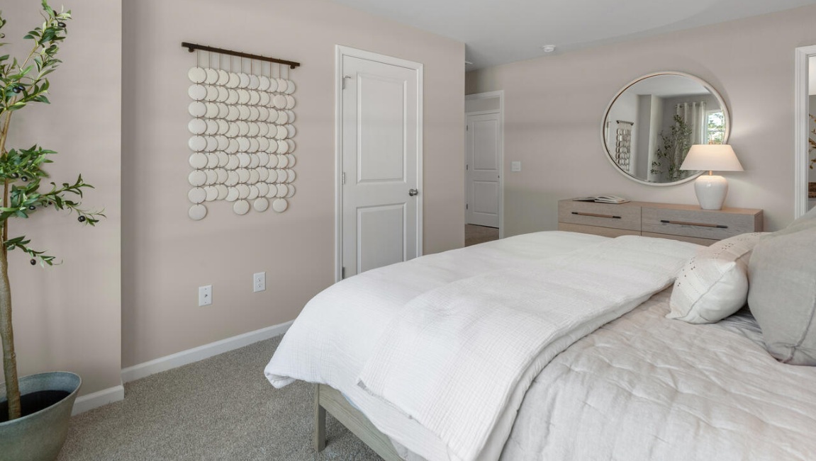 The second floor features the primary bedroom with a walk-in closet and double vanities. It also includes two additional bedrooms, a shared bathroom, and a laundry room for convenience.