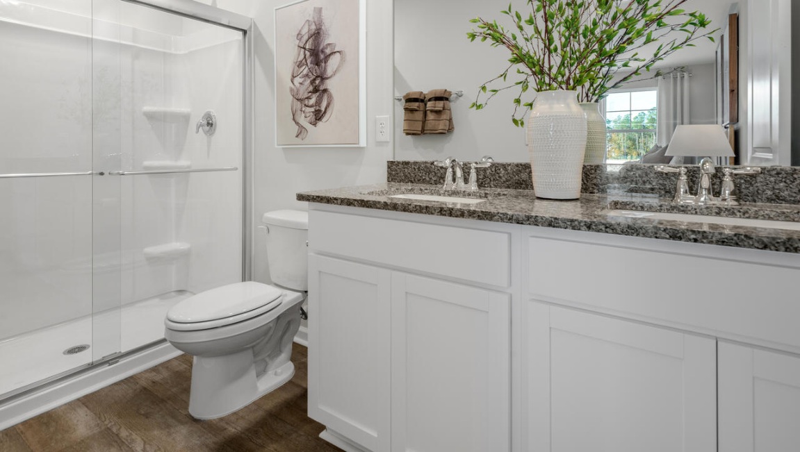 The second floor features the primary bedroom with a walk-in closet and double vanities. It also includes two additional bedrooms, a shared bathroom, and a laundry room for convenience.