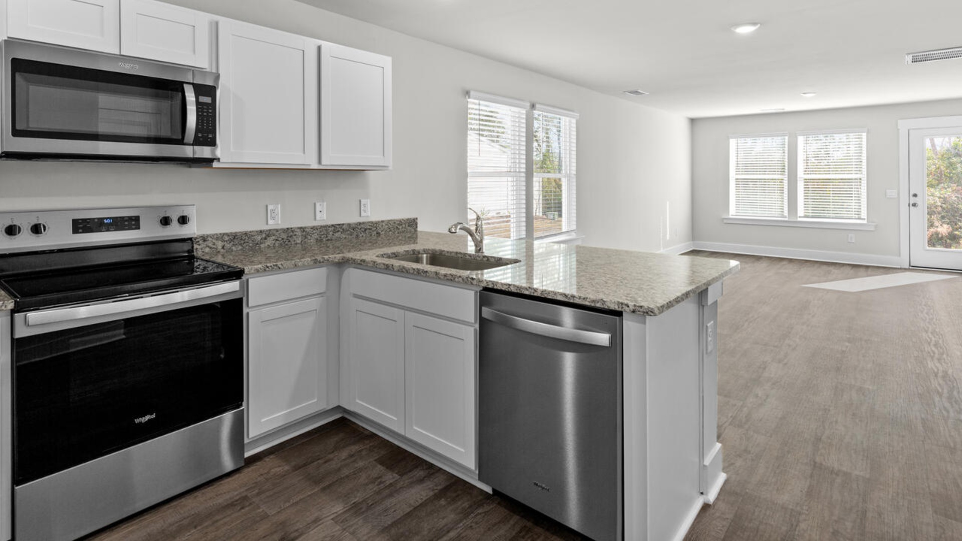 The kitchen is equipped with stainless steel appliances and granite countertops. Additionally, the first floor includes a half bath, laundry room, and storage space.