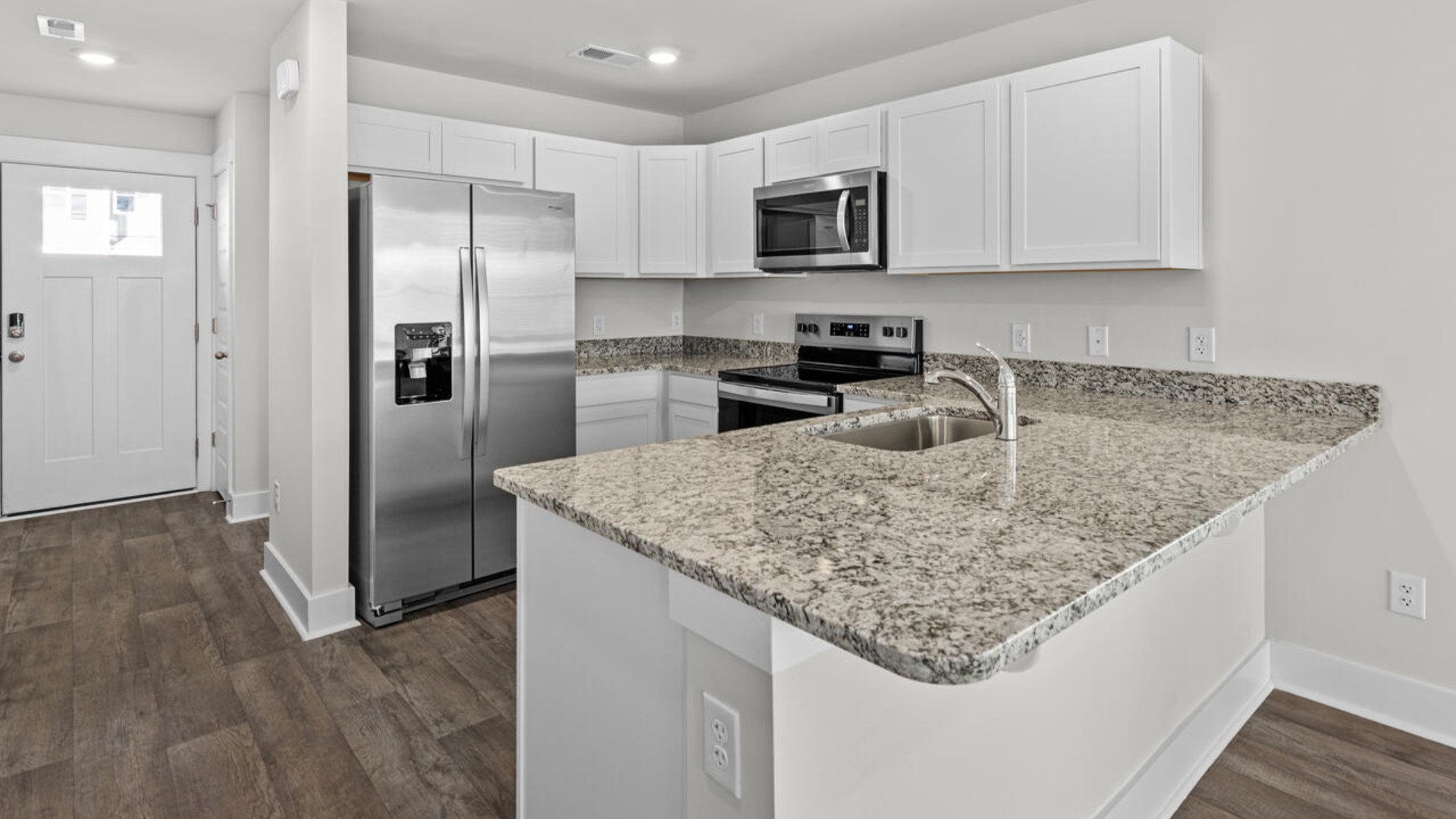 The kitchen is equipped with stainless steel appliances and granite countertops. Additionally, the first floor includes a half bath, laundry room, and storage space.