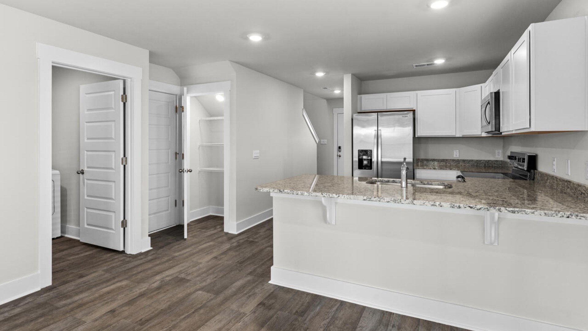 The kitchen is equipped with stainless steel appliances and granite countertops. Additionally, the first floor includes a half bath, laundry room, and storage space.