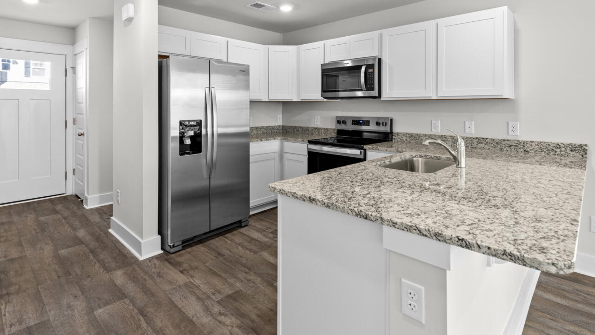 The kitchen is equipped with stainless steel appliances and granite countertops. Additionally, the first floor includes a half bath, laundry room, and storage space.