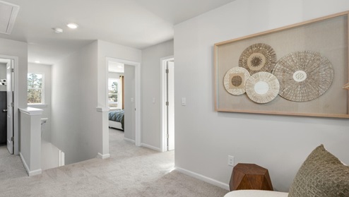 The second floor features the primary bedroom with a walk-in closet and double vanities. It also includes two additional bedrooms, a shared bathroom, and a laundry room for convenience.