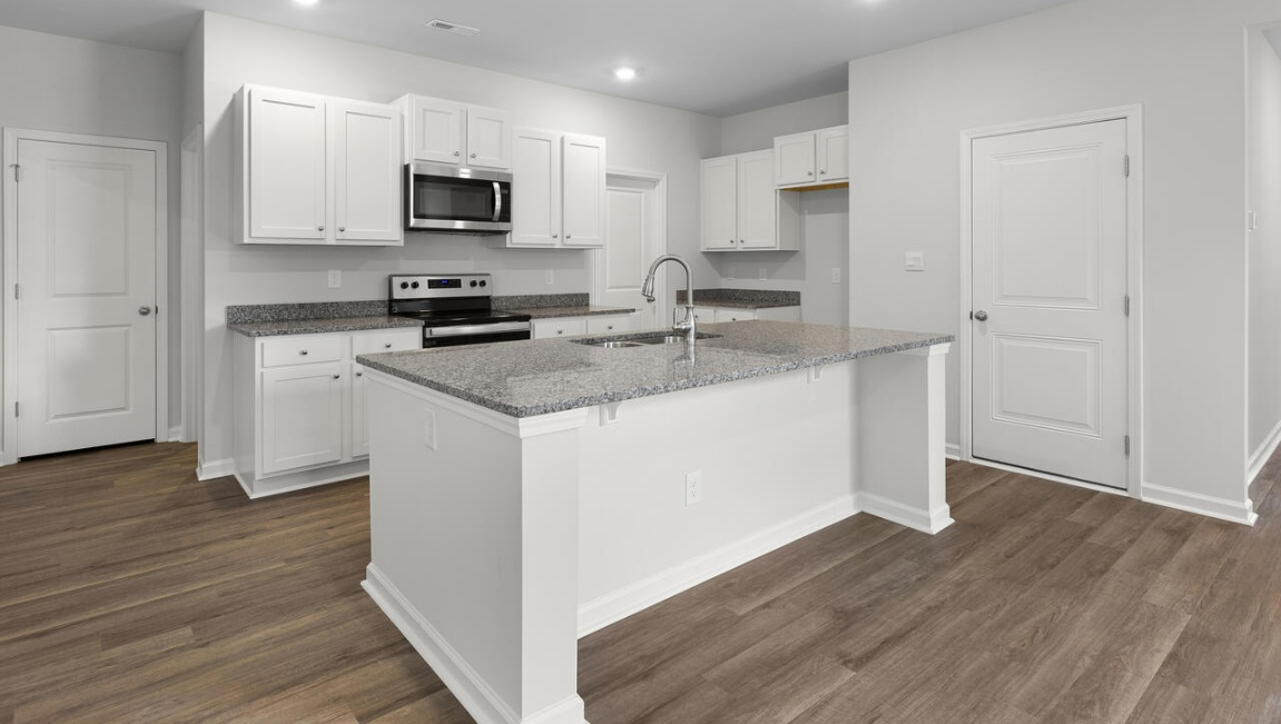 The gourmet kitchen stands out with its elegant granite countertops and stainless steel appliance package. Throughout the home, Luxury Vinyl Plank (LVP) flooring and stain-resistant carpets offer durability and comfort.