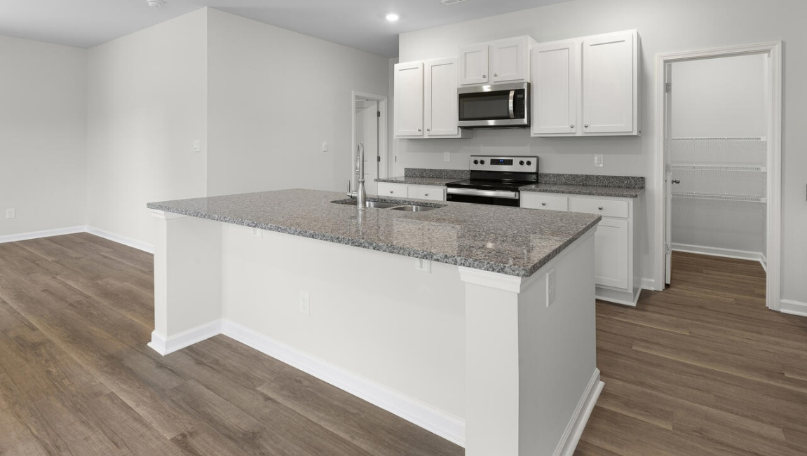 The gourmet kitchen stands out with its elegant granite countertops and stainless steel appliance package. Throughout the home, Luxury Vinyl Plank (LVP) flooring and stain-resistant carpets offer durability and comfort.