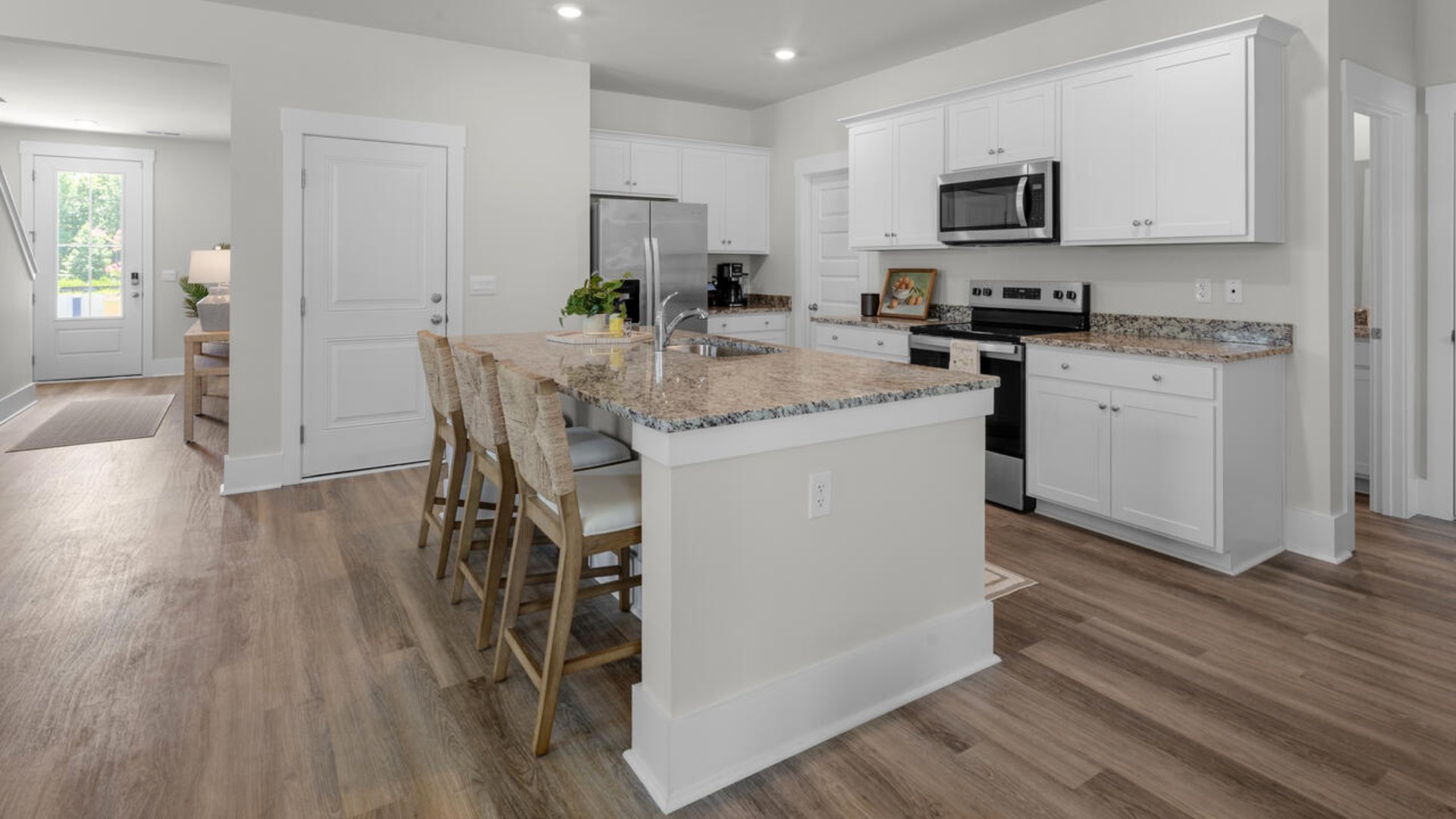 The gourmet kitchen stands out with its elegant granite countertops and Whirlpool stainless steel appliance package. Throughout the home, Luxury Vinyl Plank (LVP) flooring and stain-resistant carpets offer durability and comfort.