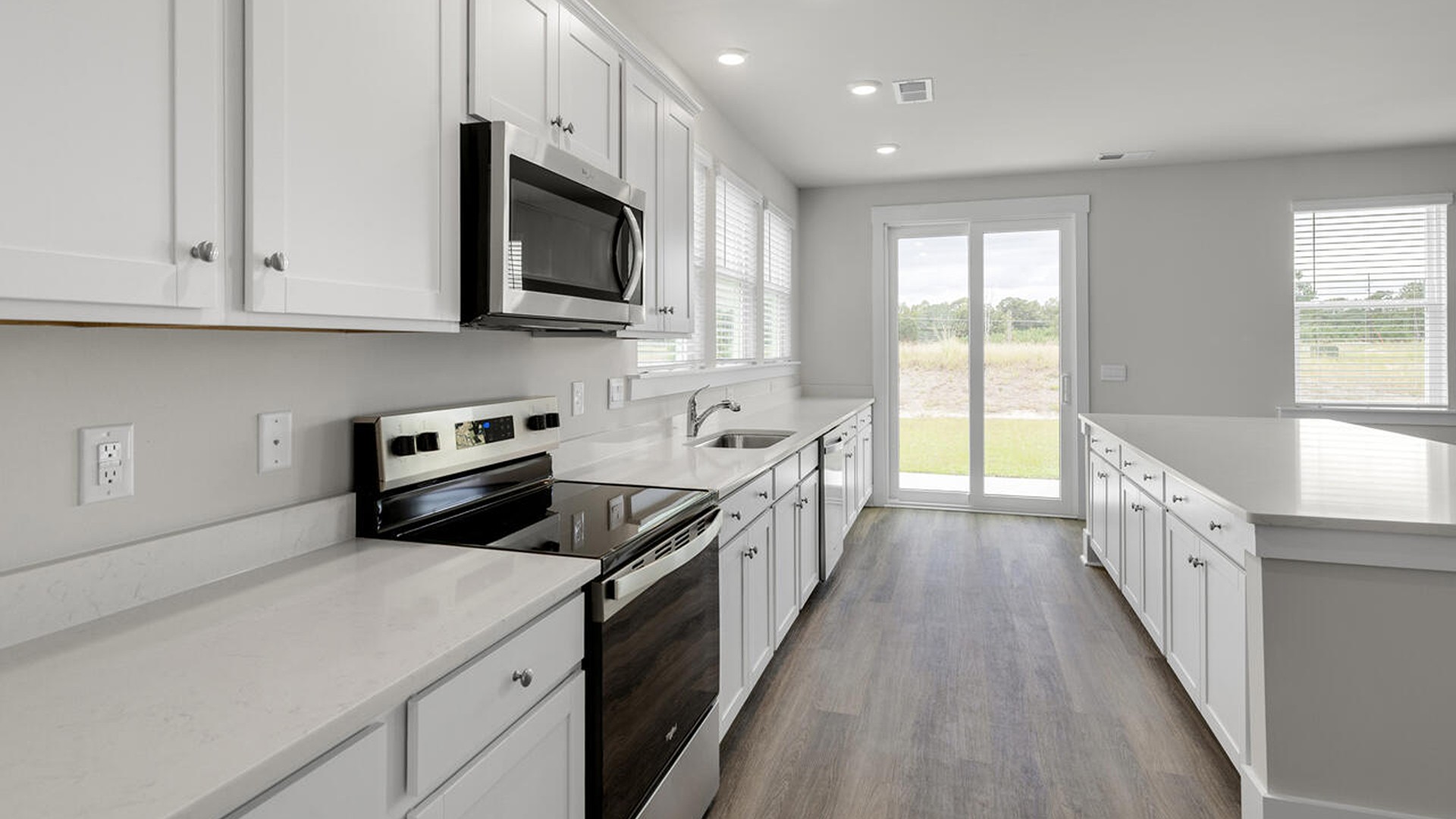 A large kitchen featuring granite countertops, stainless steel appliances and an island that offers ample room for food preparation and casual dining,